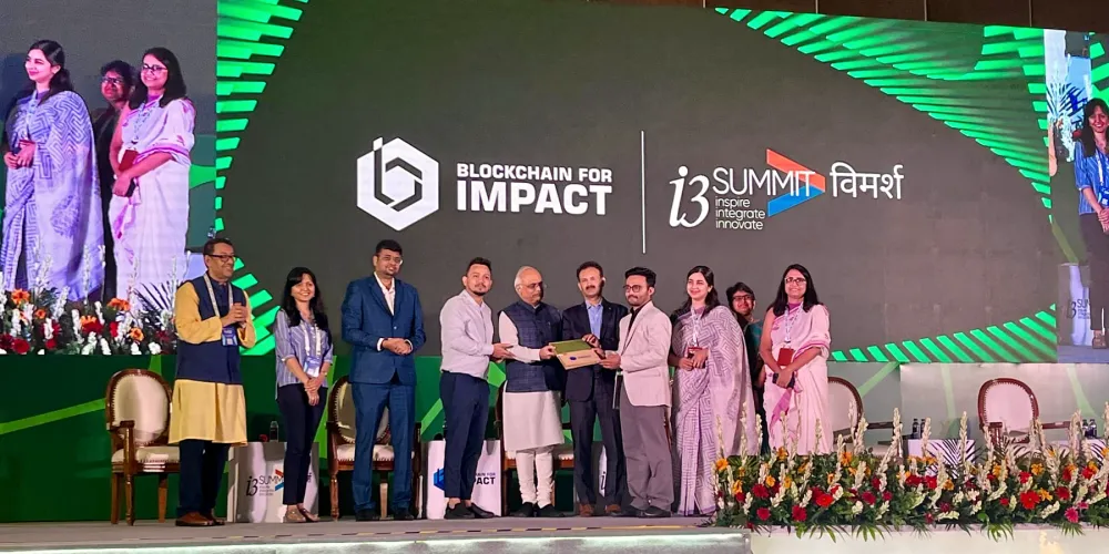 The BioMarkIQ team on stage with hosts at the Blockchain for Impact i3 Summit.