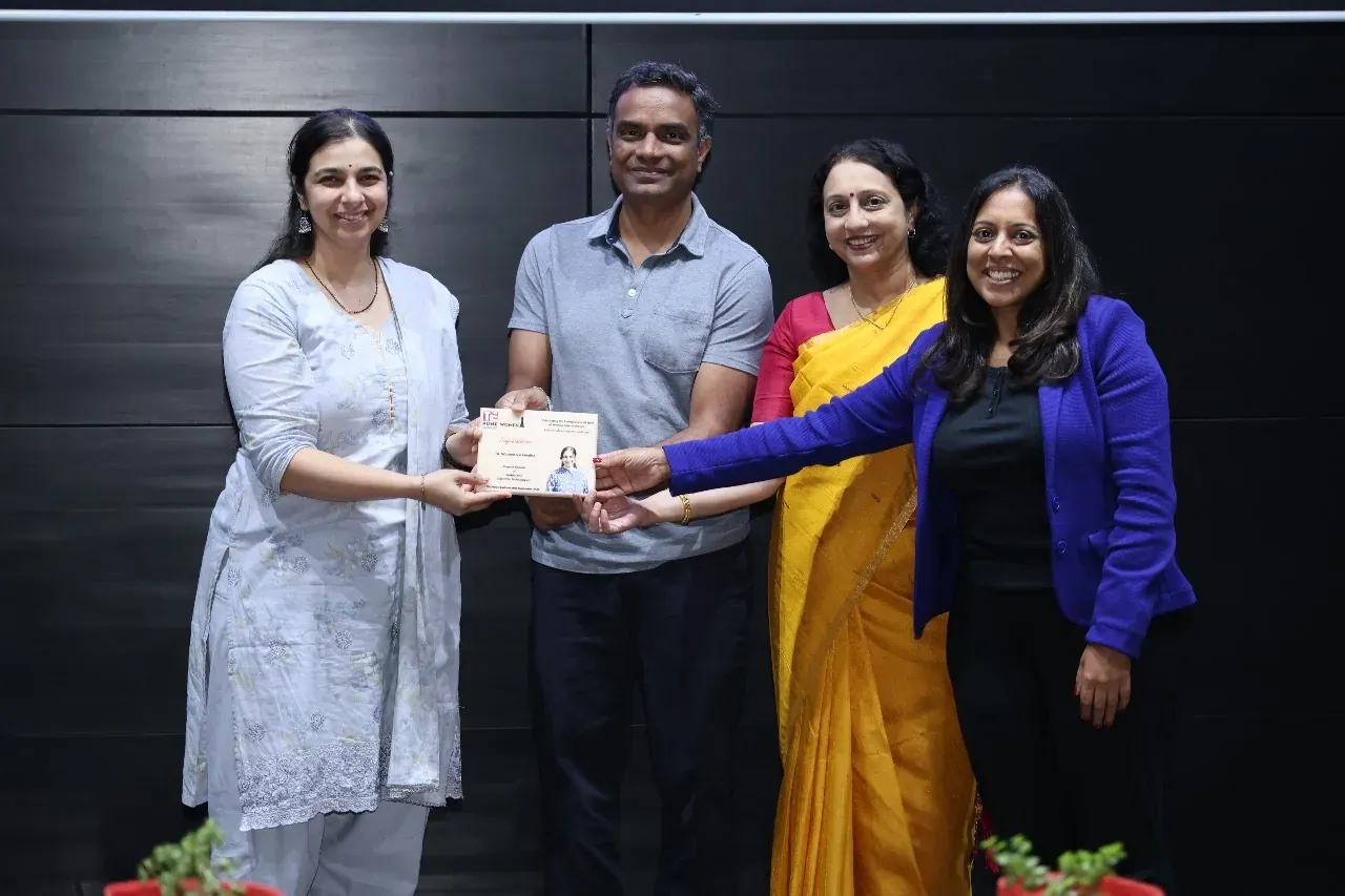 Manasi Khasnis receives a TiE Pune Women certificate bearing her photo from three hosts.